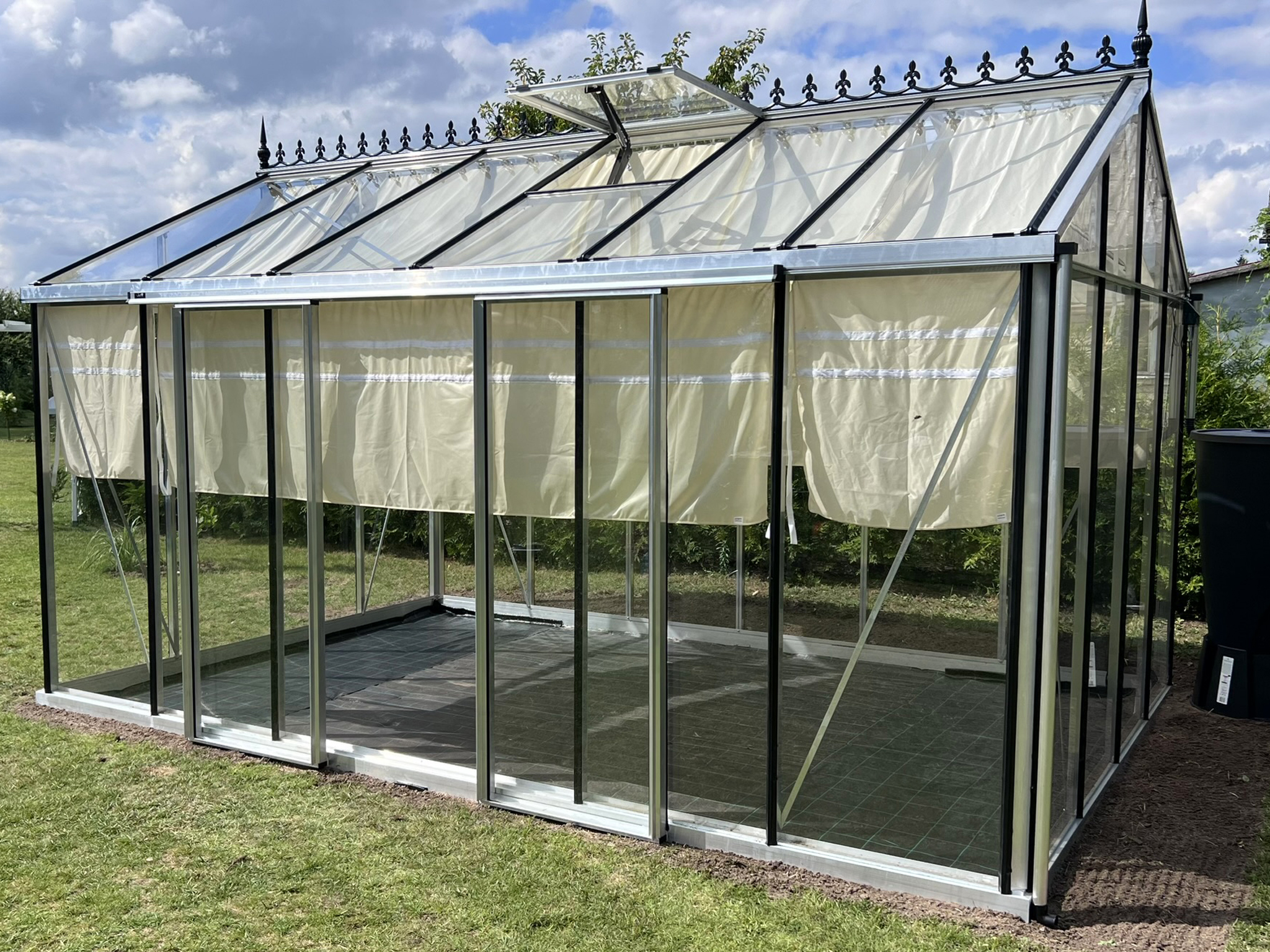 Janssens MASTER greenhouse with shading curtains, rainwater barrel and solar irrigation system.